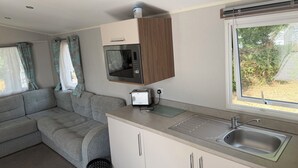 Una kitchenette compacta con microondas, tostadora y pileta.