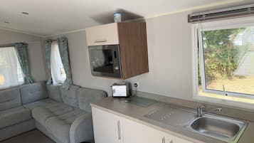 Una kitchenette compacta con microondas, tostadora y pileta.