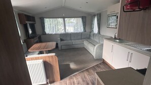 Un espacio habitable compacto con kitchenette, un sofá y zona de comedor.