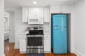 A kitchen with white cabinets, a stainless steel oven, a blue refrigerator, and a microwave. - Private Rifle Range Cottage -near IOP & Charleston (Mount Pleasant)