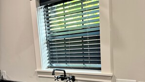 A kitchen with a built-in sink, a window with blinds, and a pendant light. - Modern Craftsman Home in Houston's Historic 1st Ward/Heights (Houston)