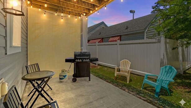 An outdoor patio with a grill, chairs, and string lights. - Pier View-sleeps 10-pets-walk to Beach (Myrtle Beach)