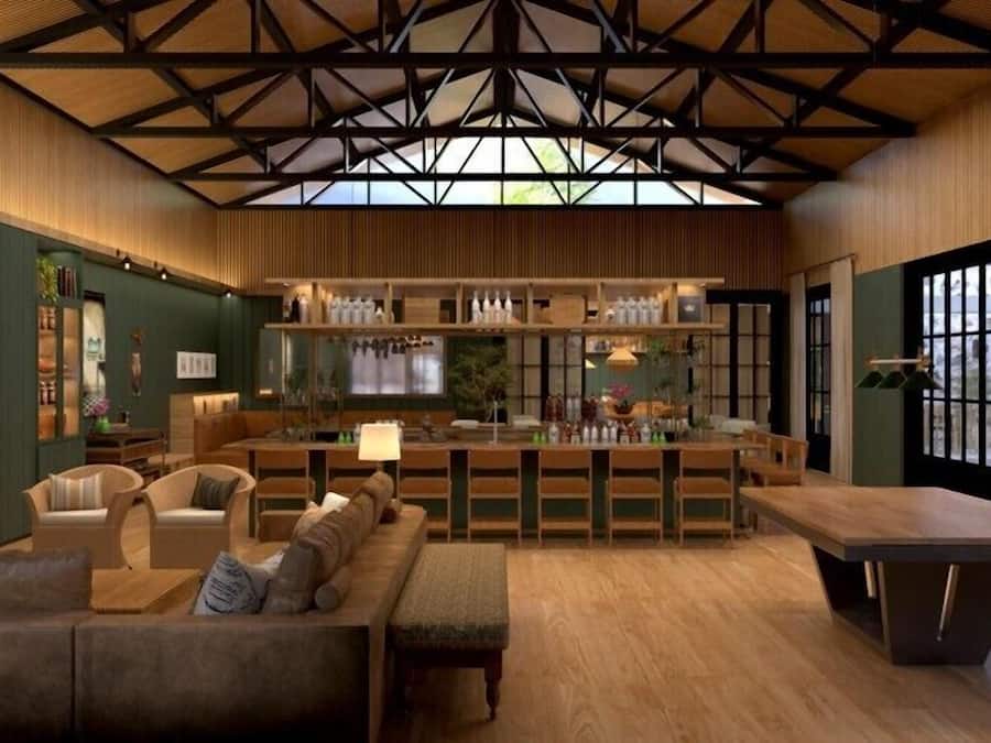A modern interior with a bar area, seating, and a high ceiling with exposed beams.