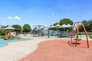 Ein Spielplatz mit Schaukeln, Rutschen und Klettergerüsten.