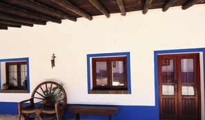Un edificio con fachada blanca, detalles azules, puertas y ventanas de madera.