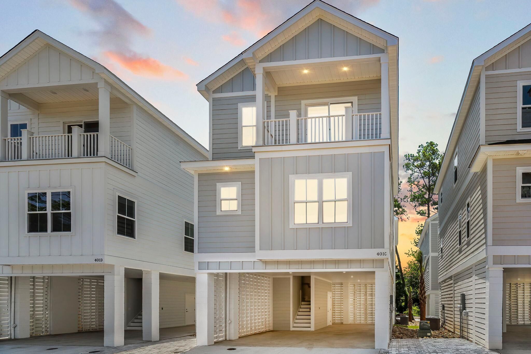 A multi-story residential building with a central entrance, balconies, and a garage.