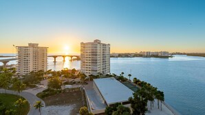 A high-rise hotel with a view of the sunset over a body of water and a bridge. - Lovers Key #508 (Fort Myers Beach)