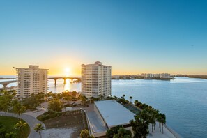 A high-rise hotel with a view of the sunset over a body of water and a bridge. - Lovers Key #508 (Fort Myers Beach)