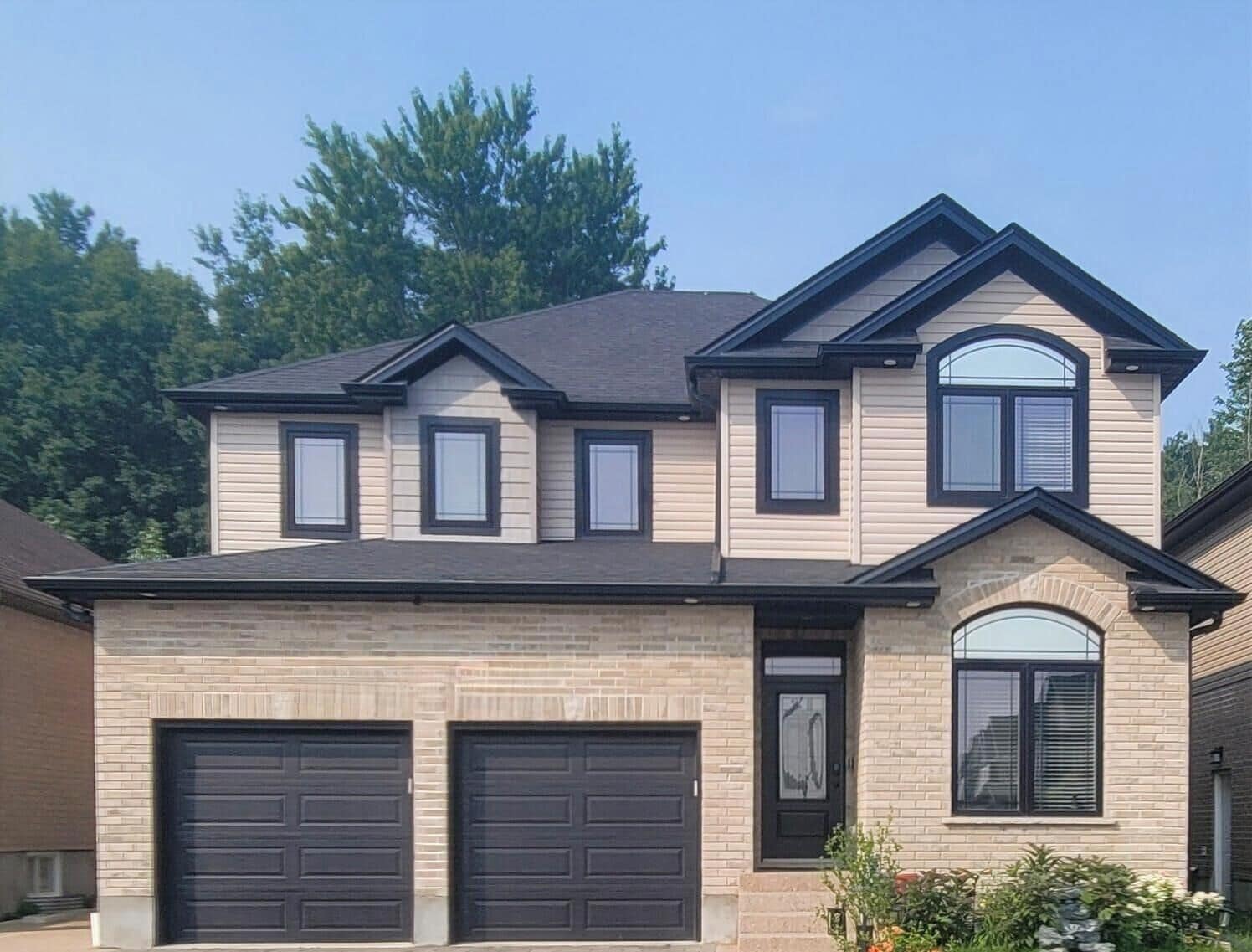 A two-story house with a garage, a front entrance, and a small porch area.