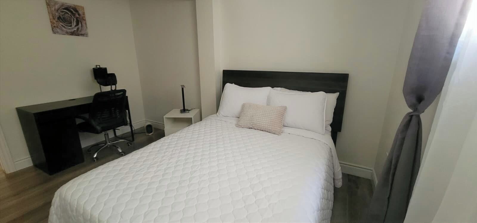 Un dormitorio con cama, escritorio y silla.