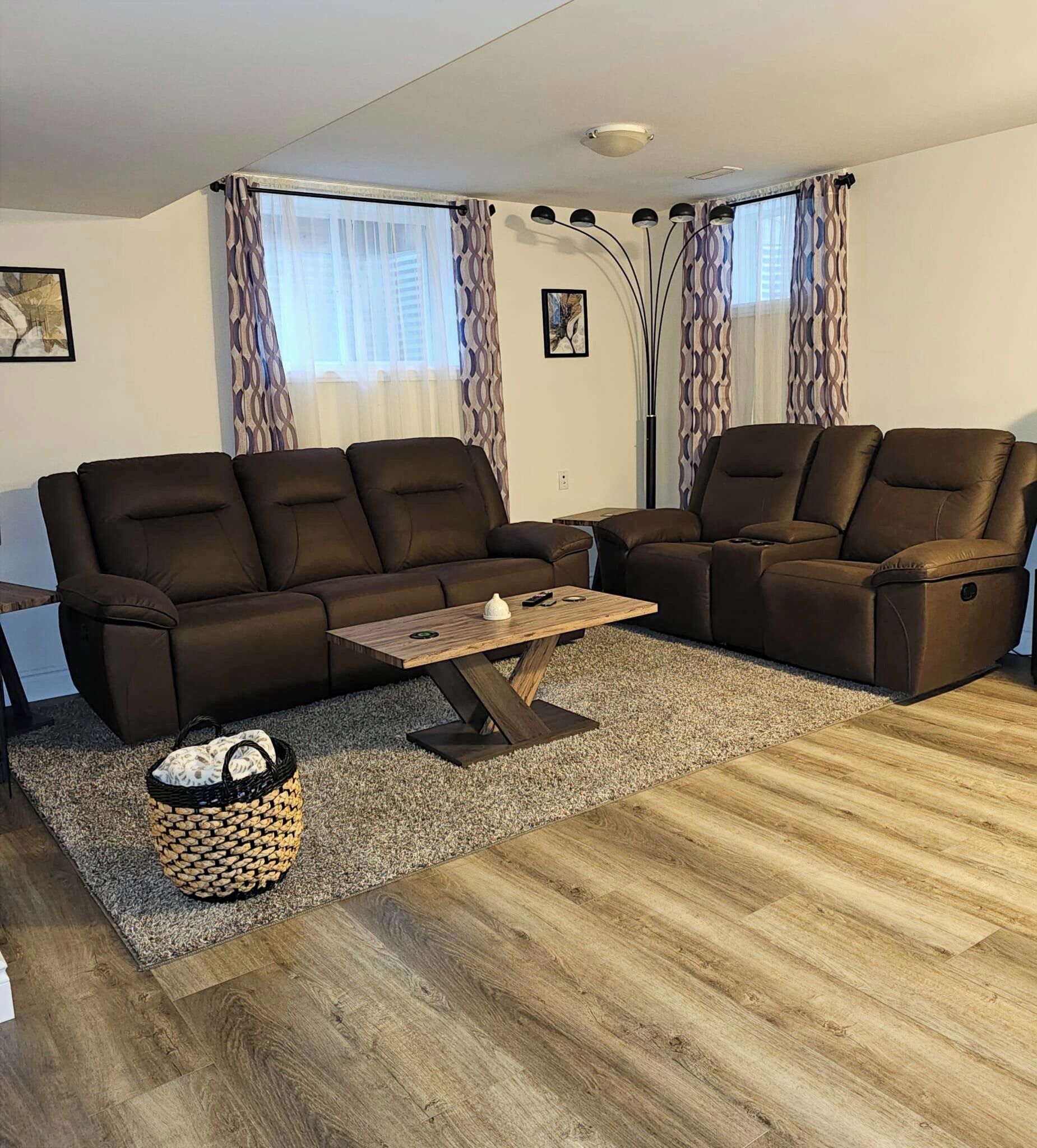 A modern living room with a sofa set, a coffee table, and a patterned rug.