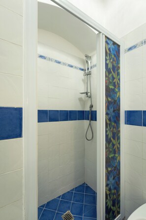 A shower with white and blue tiles, a showerhead, and a drain. - Just a short walk from the Ponte Vecchio, away from the noise (Firenze)