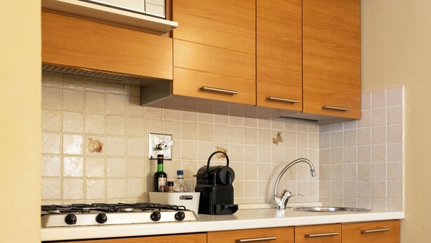 Una cocina con armarios de madera, un microondas, una estufa y un lavamanos.