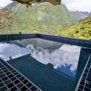 Vista clara de una piscina con montañas al fondo.