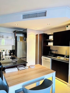 A modern kitchen with a built-in stove, microwave, and dishwasher. - Stylish 2-Bed Apartment with Pool, Gym & Mountain Views. Walk to V&A Waterfront! (Cape Town)