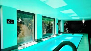 A swimming pool with glass walls, a metal handrail, and a clock on the wall. - Stylish 2-Bed Apartment with Pool, Gym & Mountain Views. Walk to V&A Waterfront! (Cape Town)