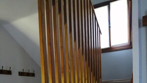 A staircase with wooden railings and a view of the outside through a window.