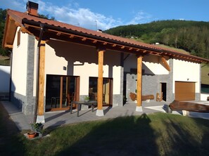 A modern house with a patio, wooden beams, and a mountain backdrop. - Rural House 'Argixti' with Mountain Views (Sunbilla)
