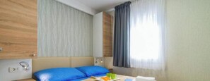 A hotel room with a bed, a bedside table, a lamp, and a window with curtains. - Apartment Mobile Home, Banjole (Marčana)