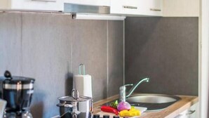 Eine moderne Küche mit Kaffeemaschine, Wasserkocher und Spüle.