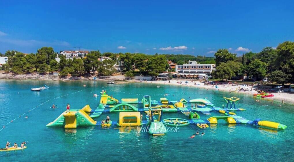 Une plage dotée d’aires de jeux aquatiques et bordée d’une mer d’un bleu limpide.