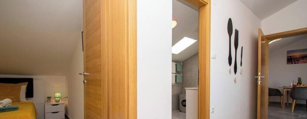 Una camera da letto con un letto, un comodino e una porta che dà su un bagno.