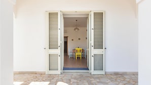 An open doorway leading to a dining area with a table and chairs. - Domus Maris Felloniche by BarbaHouse (Castrignano del Capo)