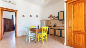 A kitchen with a dining table, chairs, and a built-in oven. - Domus Maris Felloniche by BarbaHouse (Castrignano del Capo)