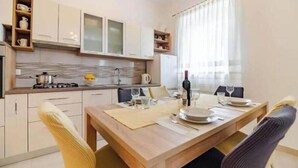 Een moderne keuken met een eettafel gedekt voor twee personen, voorzien van voorzieningen.