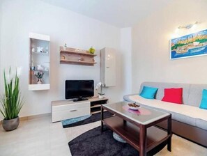 A modern living room with a sofa, TV, and a painting on the wall. - Apartment Stella, Medulin (Marčana)