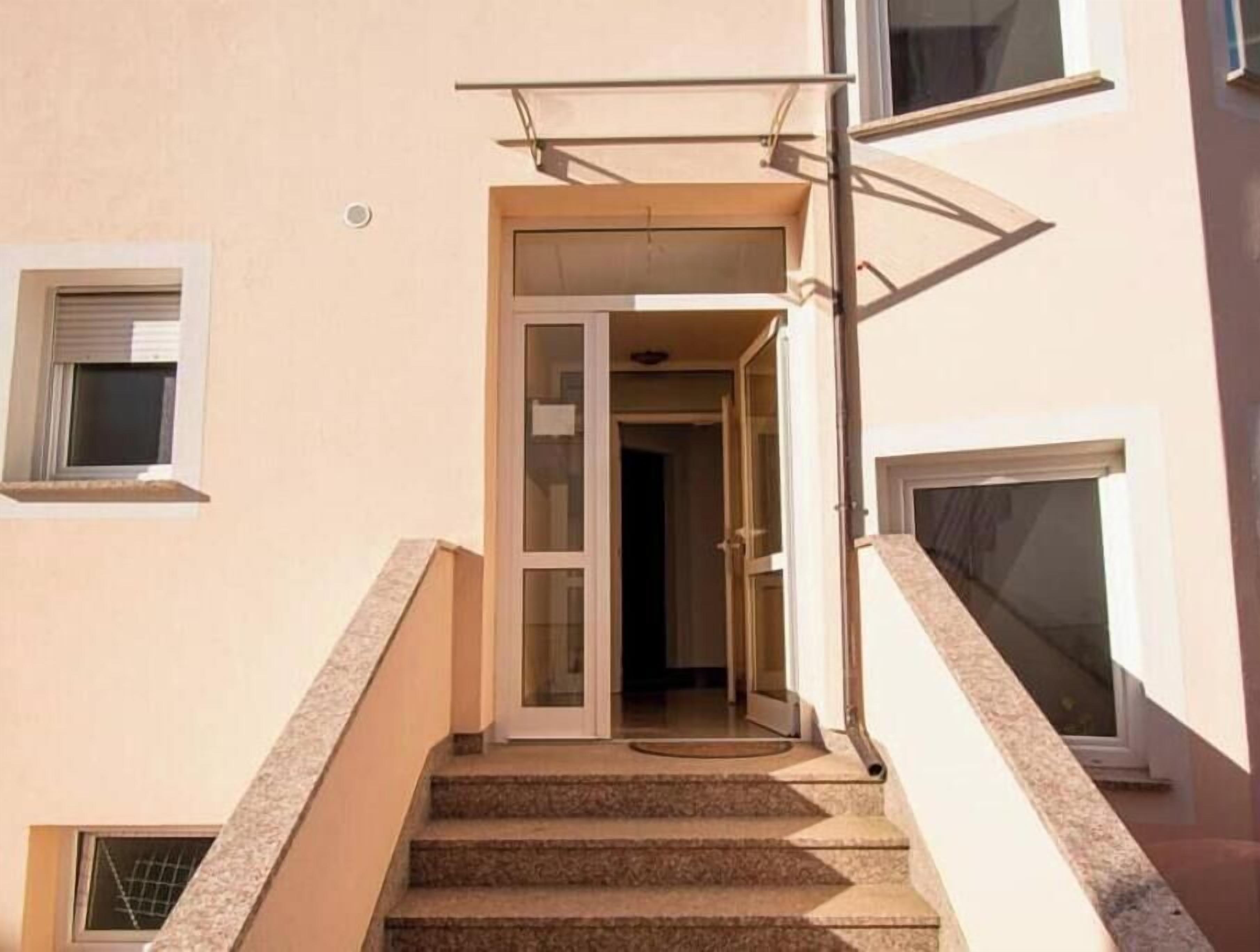 Una escalera que lleva a la entrada de un edificio, con una puerta y ventanas.