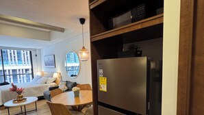 Una cucina moderna con frigorifero integrato, mensole in legno e zona pranzo con tavolo e sedie.