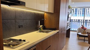 Una cucina moderna con forno integrato, lavello in acciaio inossidabile e mobili in legno.