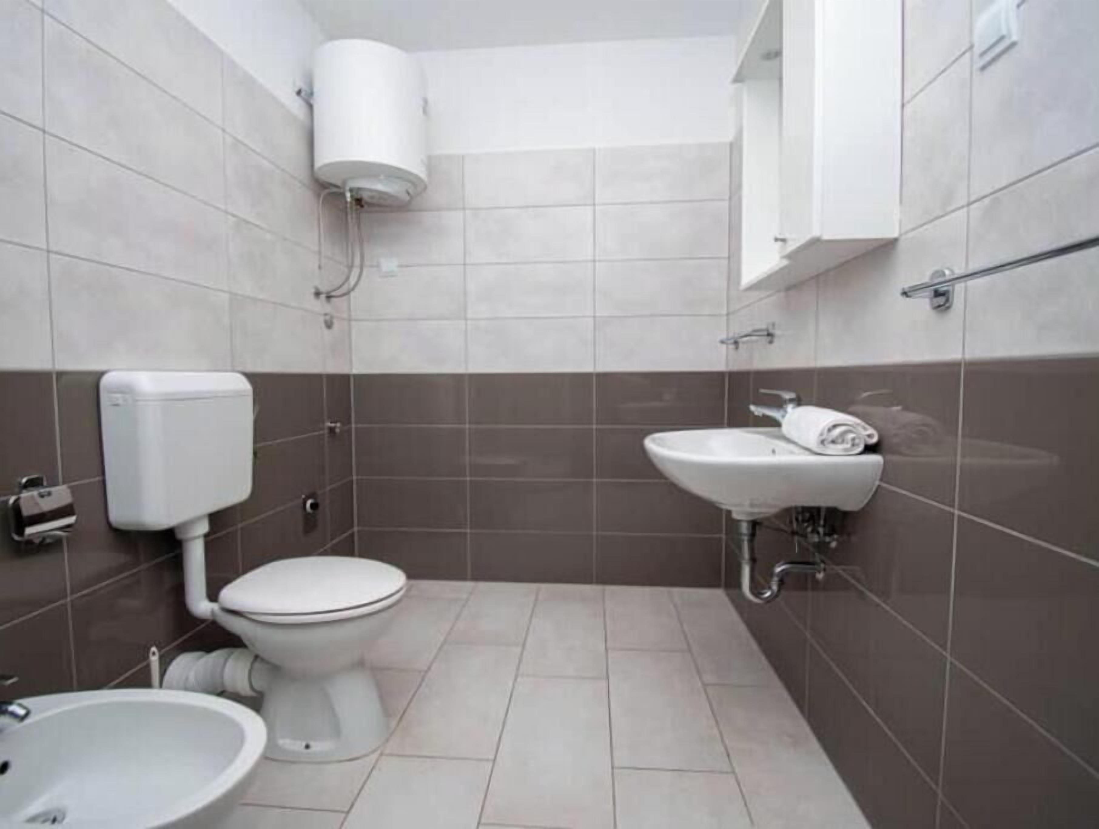 A bathroom with a toilet, bidet, and sink.