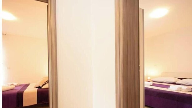 A hotel room with a bed, a bedside table, and a mirror. - A01 - C: Lotus Apartment (Marčana)