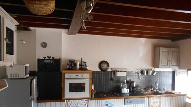 Cocina compacta con microondas, horno y cafetera.