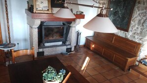 Una sala de estar acogedora con chimenea, muebles de madera y una pared de piedra.