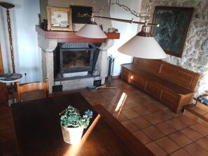 Ein gemütliches Wohnzimmer mit Kamin, Holzmöbeln und einer Steinwand.