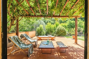 An outdoor patio with a pergola, lounge chairs, a table, and a bench. - Pool Villa with SPA in Perugia city (Perugia)