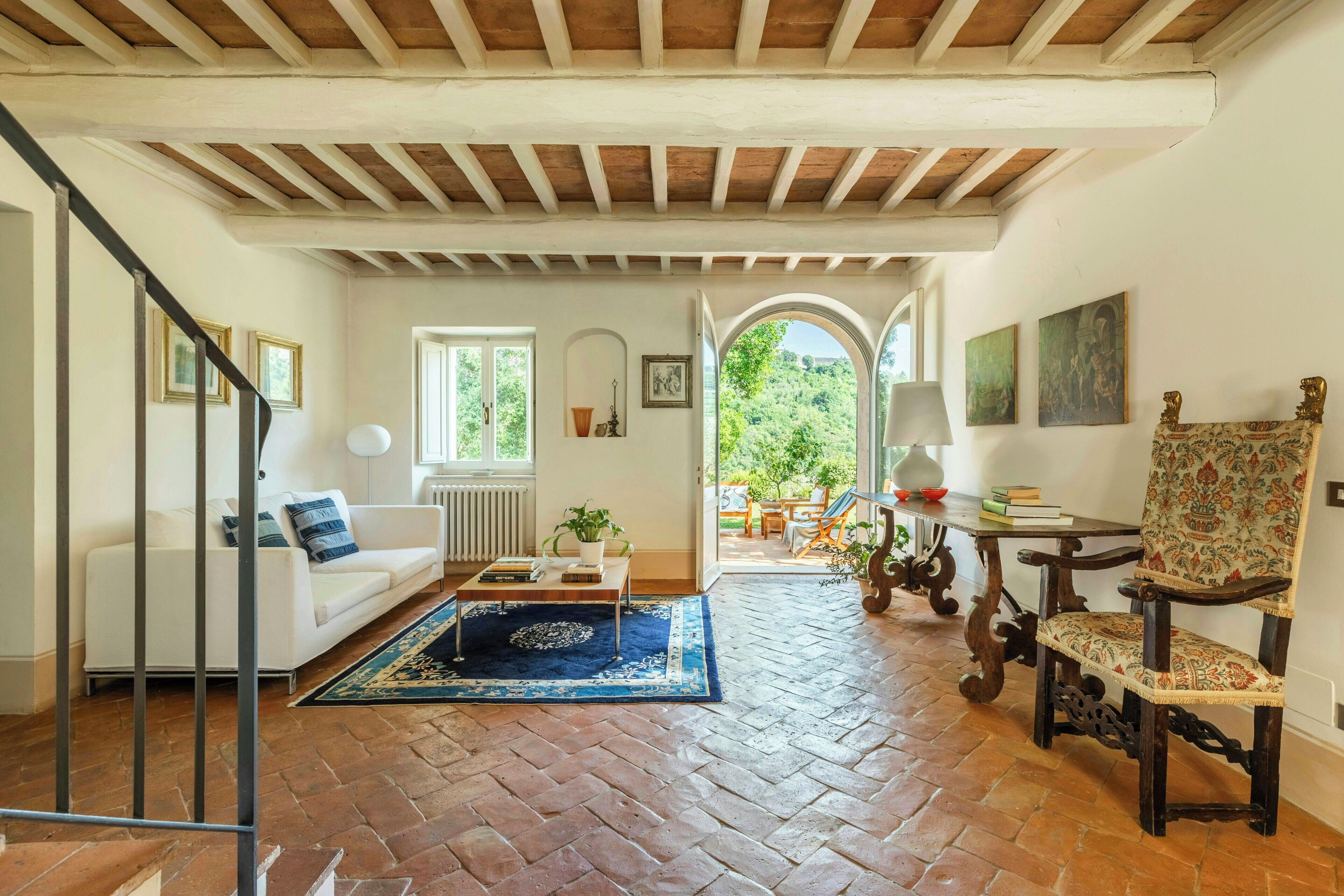 A spacious living room with a white sofa, a coffee table, and a patterned rug.