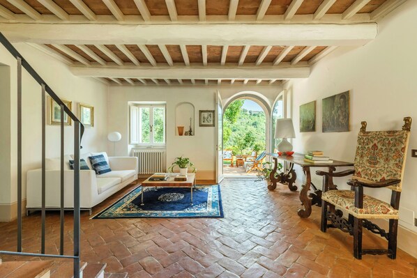 A spacious living room with a white sofa, a coffee table, and a patterned rug. - Pool Villa with SPA in Perugia city (Perugia)