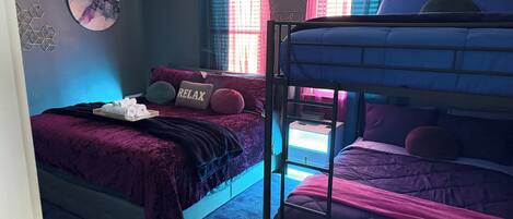 A bunk bed with a headboard, a ceiling fan, and a window with curtains.