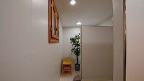 A narrow hallway with a wooden-framed mirror, a potted plant, a small wooden bench, and a tiled floor. - CAN SERENA. CAN PICAFORT. MALLORCA. NEAR THE BEACH (Can Picafort)