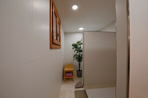 A narrow hallway with a wooden-framed mirror, a potted plant, a small wooden bench, and a tiled floor. - CAN SERENA. CAN PICAFORT. MALLORCA. NEAR THE BEACH (Can Picafort)