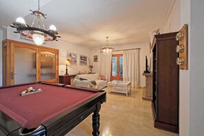 A room with a pool table, a sofa, a dining table, and a large wooden cabinet. - CAN SERENA. CAN PICAFORT. MALLORCA. NEAR THE BEACH (Can Picafort)