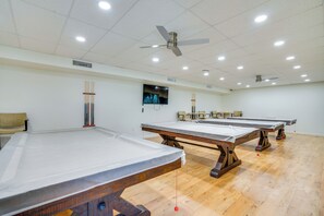 A room with multiple pool tables, ceiling fans, recessed lighting, and a television on the wall. - Relaxed Resort-style Living Near Fort Myers Beach (Fort Myers)