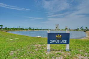 A sign for Swan Lake with a view of a lake and buildings in the background. - Relaxed Resort-style Living Near Fort Myers Beach (Fort Myers)