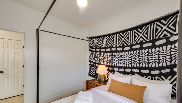 A hotel room with a bed, a nightstand with a lamp, a patterned headboard, and a door. - Relax Poolside! Retreat 2 Mi to Santan Mtn Casino (Chandler)