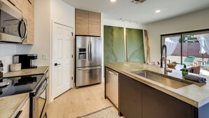 A modern kitchen with stainless steel appliances, a built-in oven, and a large island with a sink. - Relax Poolside! Retreat 2 Mi to Santan Mtn Casino (Chandler)