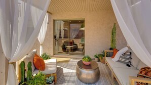 A sunlit room with a sofa, a round table, and a glass door leading outside. - Relax Poolside! Retreat 2 Mi to Santan Mtn Casino (Chandler)